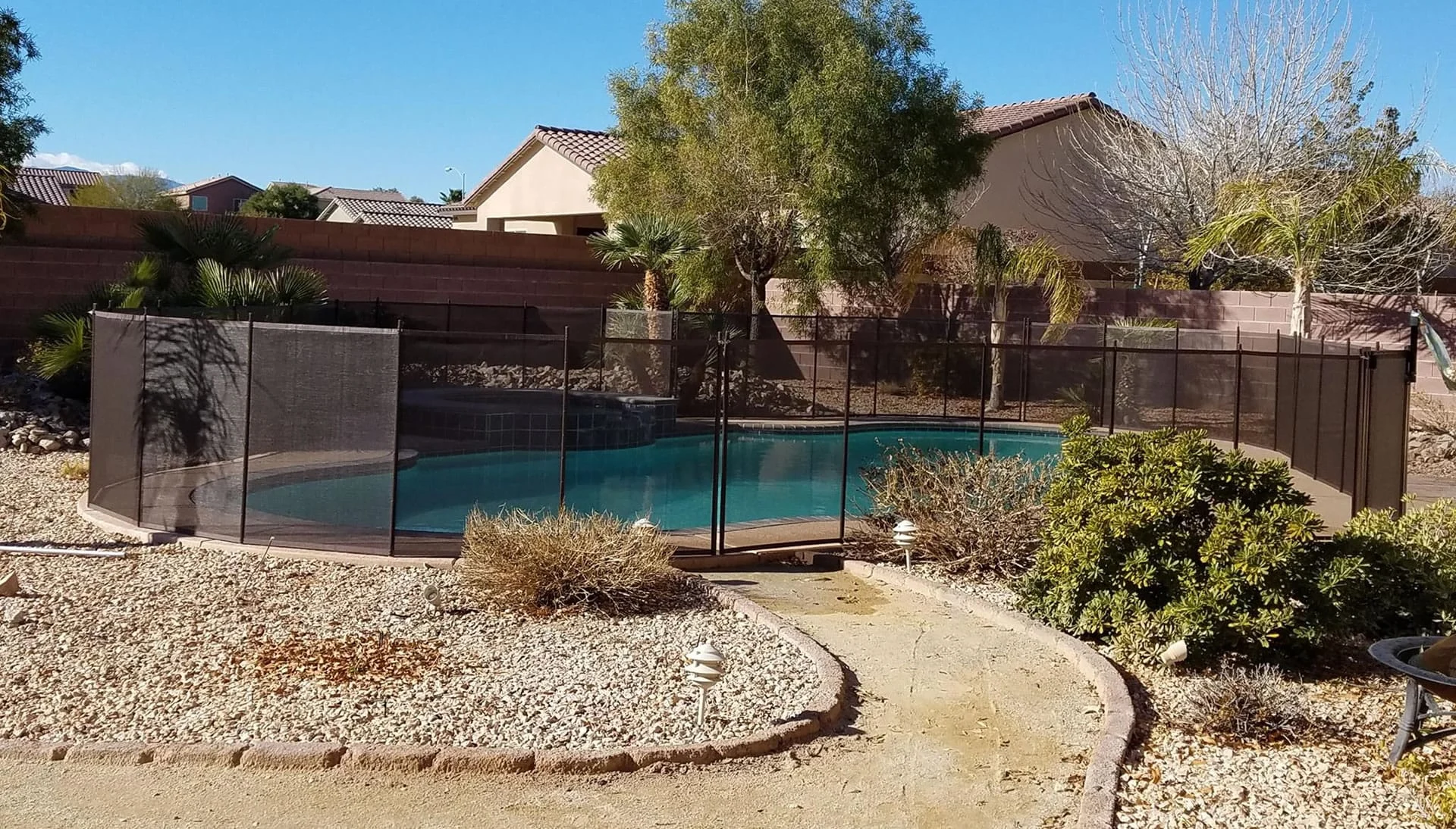 Mesh pool fence around an Arizona backyard swimming pool
